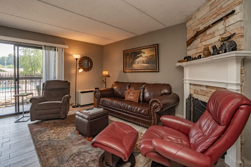 Sink into plush leather seating and feel your worries melt away in this welcoming living space, where rustic stone fireplace charm meets modern comfort—your perfect retreat after a day of adventure.